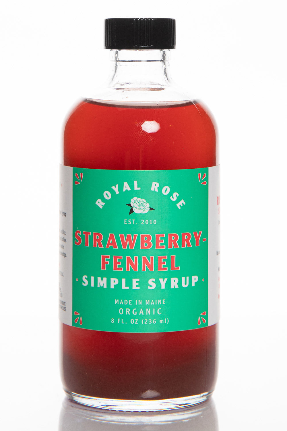 A bottle of Strawberry Fennel Simple Syrup with a green label, red liquid, and text stating it is organic and handmade in Maine. 8oz unit.